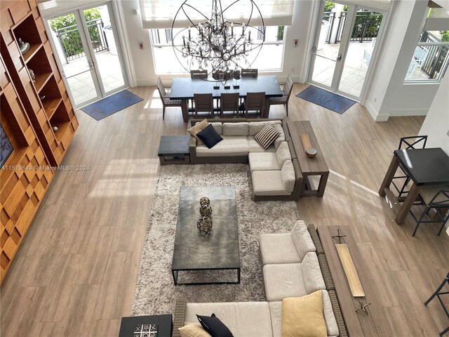 living room with hardwood / wood-style floors, a notable chandelier, and french doors