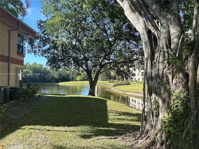 view of yard with a water view and central AC unit