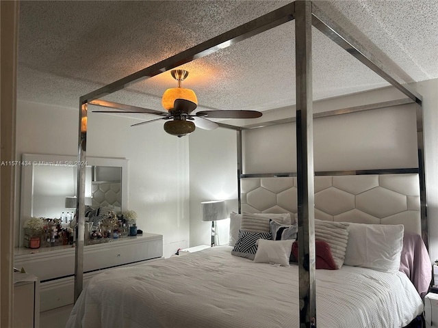 bedroom featuring beam ceiling, ceiling fan, and a textured ceiling