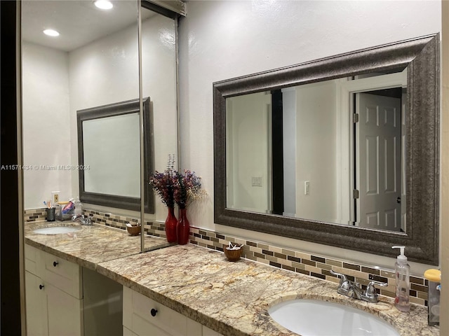 bathroom with vanity with extensive cabinet space and backsplash