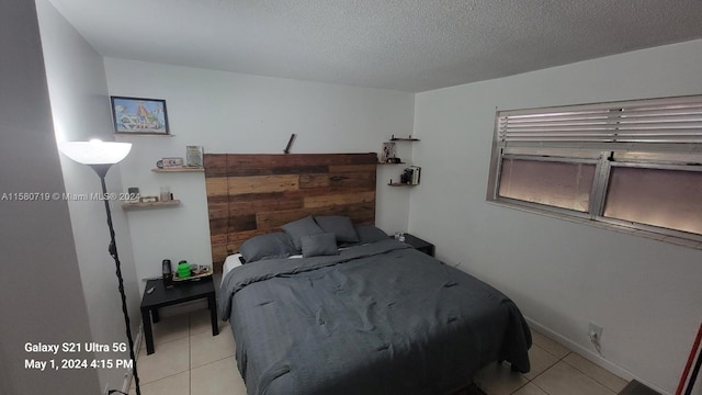 bedroom featuring light tile patterned floors and a textured ceiling