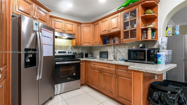 kitchen with light stone countertops, appliances with stainless steel finishes, backsplash, light tile flooring, and sink