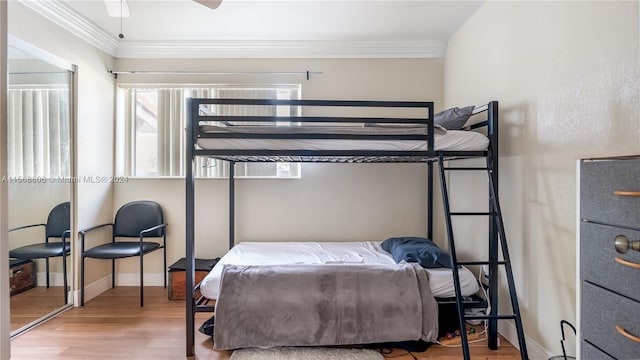 bedroom with crown molding, ceiling fan, and hardwood / wood-style floors