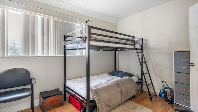 bedroom with light hardwood / wood-style floors and ornamental molding