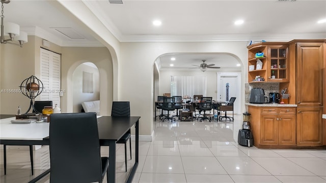 dining area with ornamental molding, ceiling fan, and light tile flooring