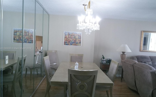 dining area with a notable chandelier and dark hardwood / wood-style flooring