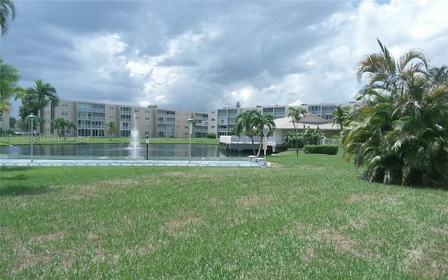 view of property's community featuring a lawn and a water view