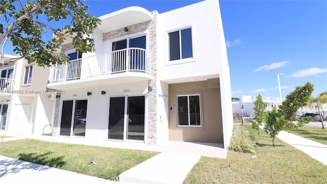 back of property featuring a yard and a balcony