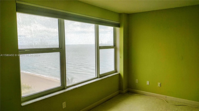 spare room with a water view and carpet floors