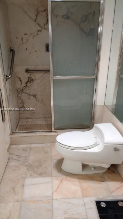 bathroom featuring walk in shower, tile patterned flooring, and toilet