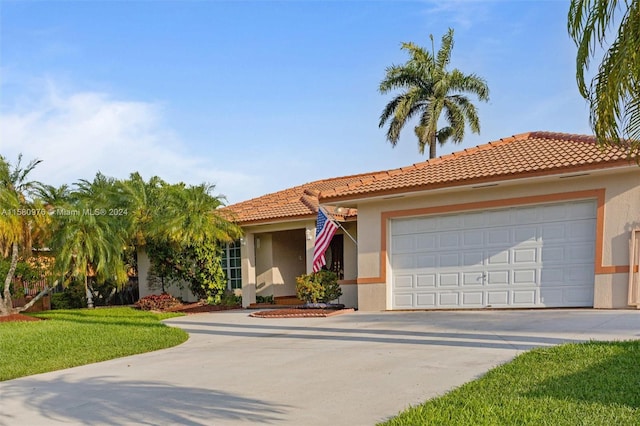 mediterranean / spanish-style house with a garage and a front lawn