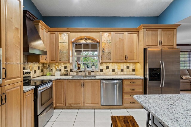 kitchen featuring appliances with stainless steel finishes, custom exhaust hood, decorative backsplash, and sink