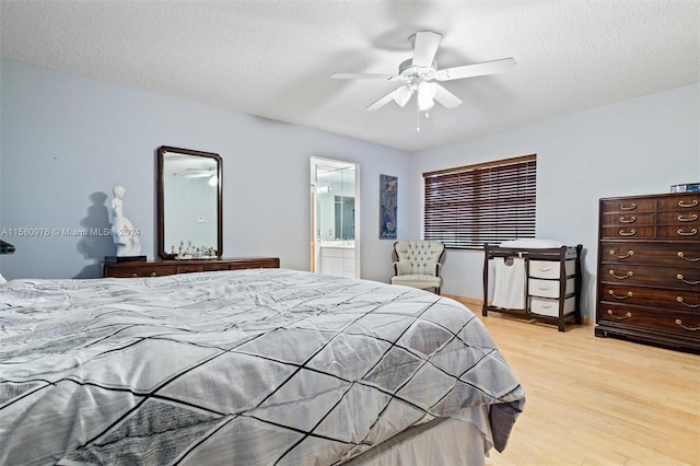 bedroom with ceiling fan, ensuite bathroom, a textured ceiling, and light hardwood / wood-style flooring