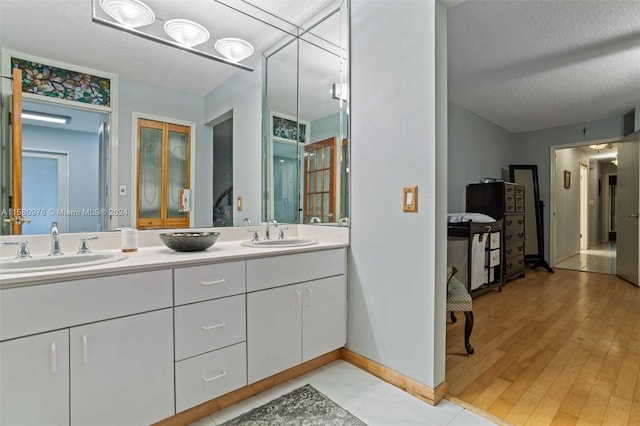 bathroom featuring wood-type flooring, a textured ceiling, and vanity