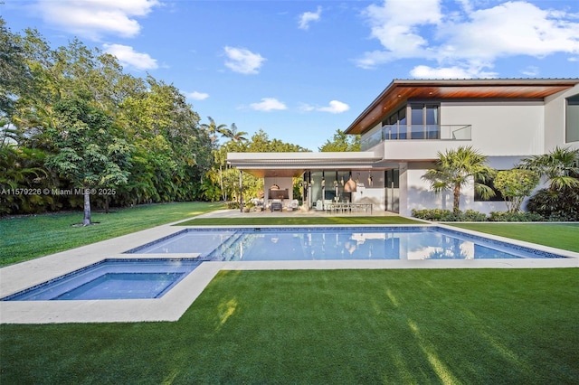 back of property with a patio area, an outdoor pool, a yard, an in ground hot tub, and stucco siding