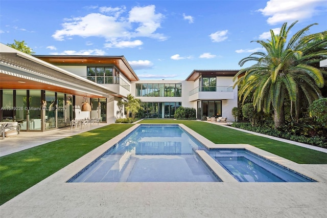 pool featuring a patio, a yard, and an in ground hot tub