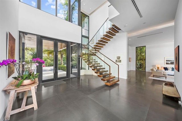 foyer with french doors, a high ceiling, and stairway