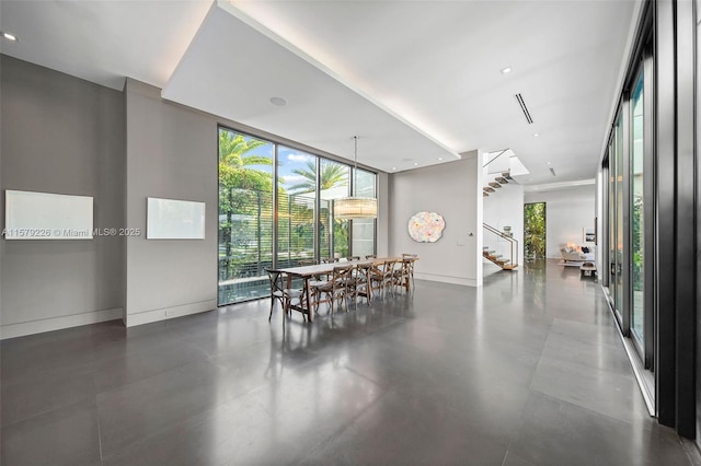 dining room with stairway, expansive windows, baseboards, and plenty of natural light