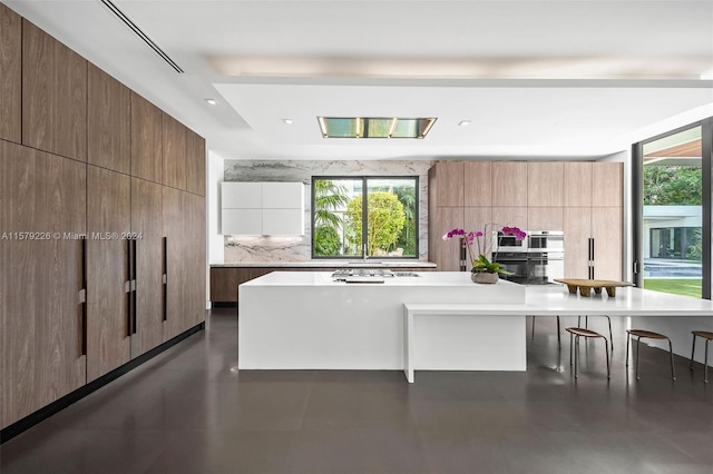 kitchen with a kitchen breakfast bar and backsplash