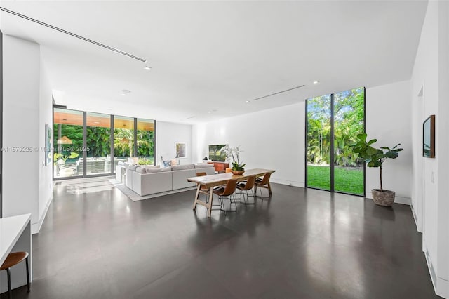 living room with finished concrete floors and a wall of windows