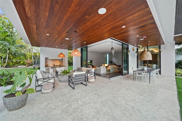 view of patio with an outdoor living space with a fireplace