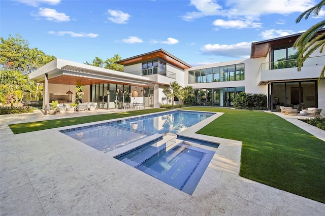 pool at dusk with an in ground hot tub, outdoor lounge area, a patio, and a lawn