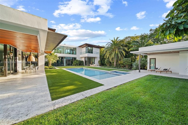 outdoor pool with a lawn and a patio