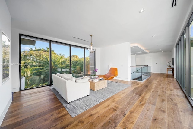 living area with baseboards, wood finished floors, and visible vents