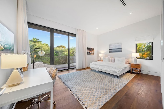 bedroom with access to outside, multiple windows, and dark wood-type flooring