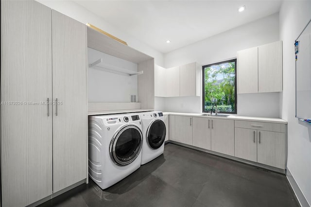laundry area with separate washer and dryer, cabinet space, a sink, and recessed lighting