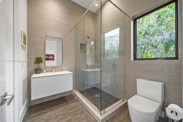full bath with tile walls, vanity, tile patterned flooring, and a stall shower