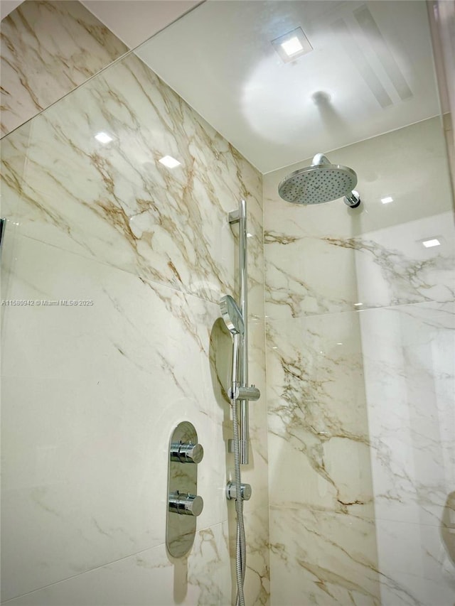 interior details featuring a tile shower