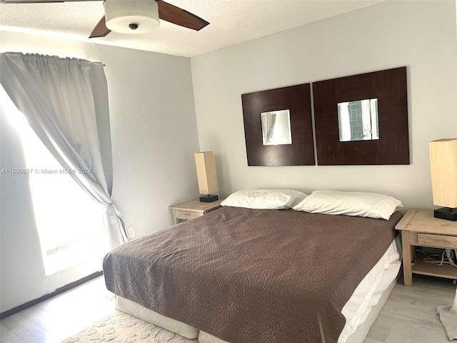 bedroom with light hardwood / wood-style flooring, ceiling fan, and multiple windows