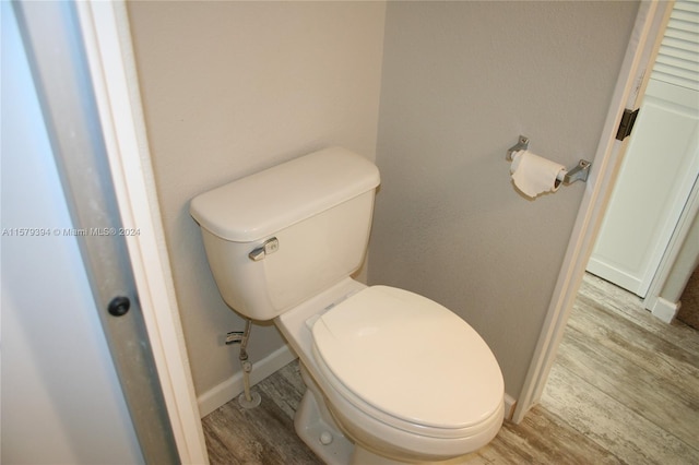 bathroom with toilet and wood-type flooring