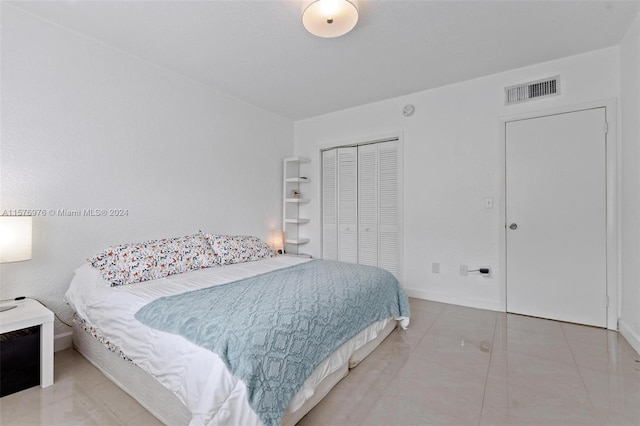 bedroom with a closet and light tile floors