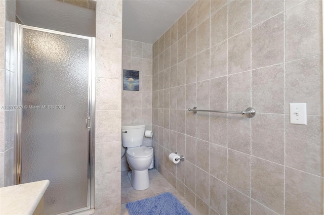 bathroom with tile walls, tile floors, toilet, and walk in shower