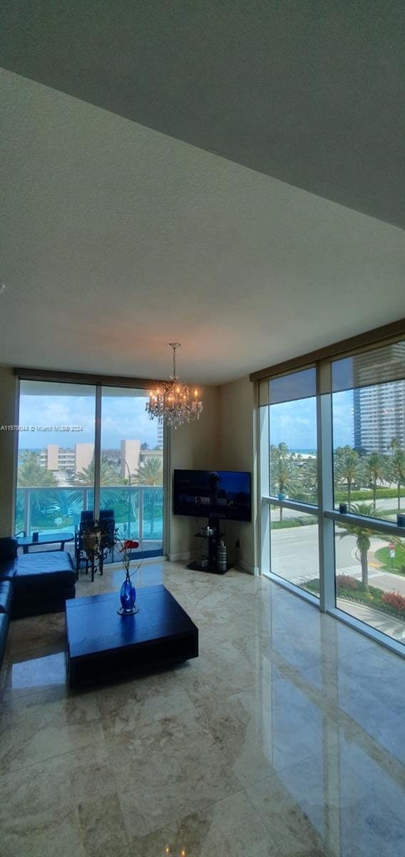 unfurnished living room featuring a wealth of natural light, a notable chandelier, expansive windows, and tile flooring