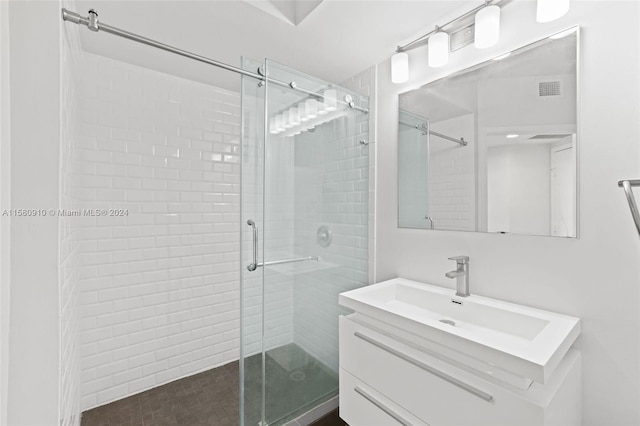 bathroom with a shower with door and vanity