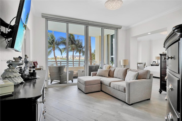 living room featuring a water view, floor to ceiling windows, crown molding, a notable chandelier, and light wood-type flooring