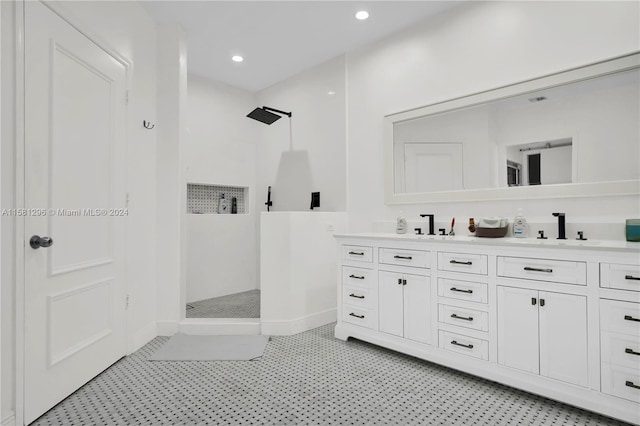 bathroom with tiled shower, tile floors, and double vanity