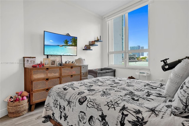 bedroom with light hardwood / wood-style floors and crown molding