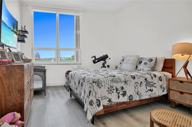 bedroom featuring hardwood / wood-style floors and crown molding