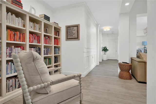 living area featuring hardwood / wood-style flooring and ornamental molding