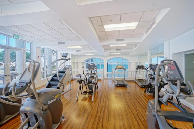 gym with hardwood / wood-style flooring and french doors