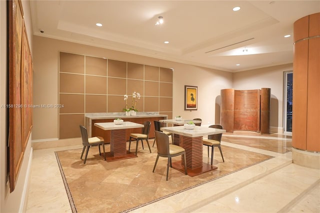 dining space featuring crown molding, light tile floors, and a tray ceiling