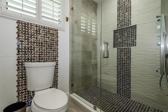 bathroom featuring toilet and an enclosed shower