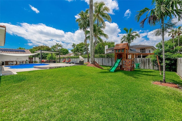 view of yard featuring a patio, a playground, and a fenced in pool