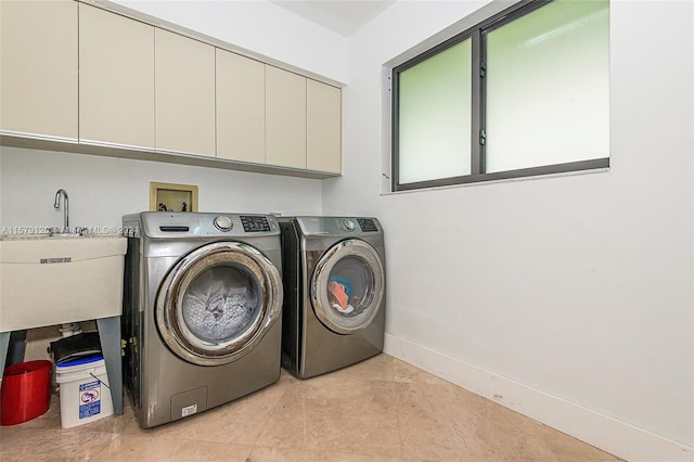 laundry area with washer and clothes dryer, cabinets, and sink