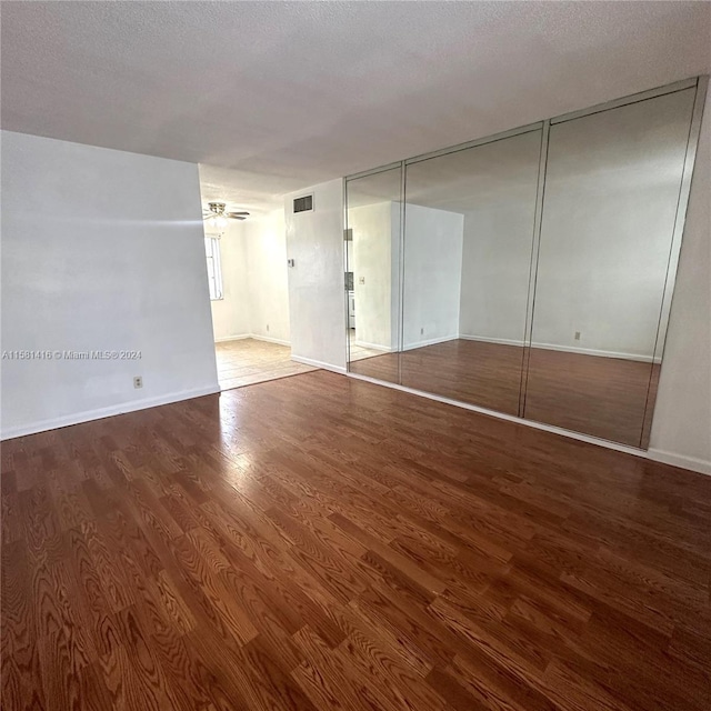 interior space with a textured ceiling, hardwood / wood-style flooring, and ceiling fan