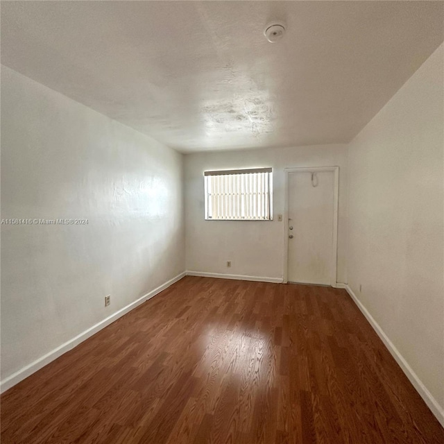 spare room with dark hardwood / wood-style flooring